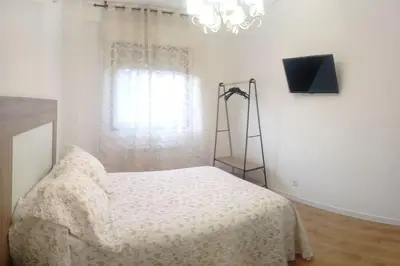 a bedroom with a bed and a ladder and a window at Piso en Ourense- Sempre Maruxiña in Ourense