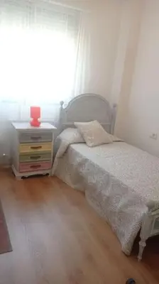 a bedroom with a bed and a dresser and a window at Piso en Ourense- Sempre Maruxiña in Ourense