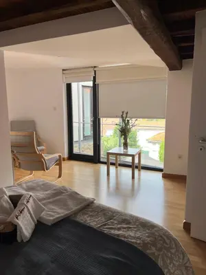 a bedroom with a bed and a table and a window at Pensión rural Pallabarro in Allariz