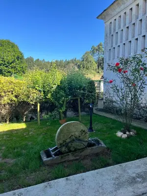 a statue in the grass next to a building at CASA GALLARDO in Ribadeo