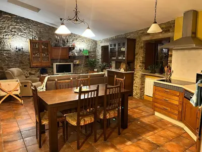a kitchen with a wooden table and a dining room at CASA GALLARDO in Ribadeo