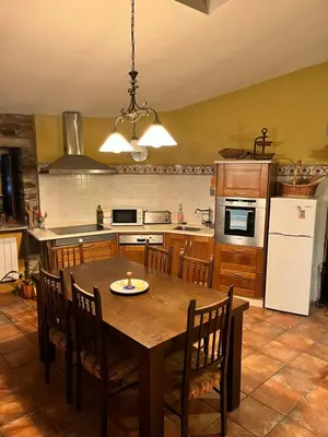 a kitchen with a table and chairs and a refrigerator at CASA GALLARDO in Ribadeo