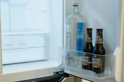 three bottles of beer in an open refrigerator at Ático Isabel, diseño y calidez junto a la Muralla Romana in Lugo