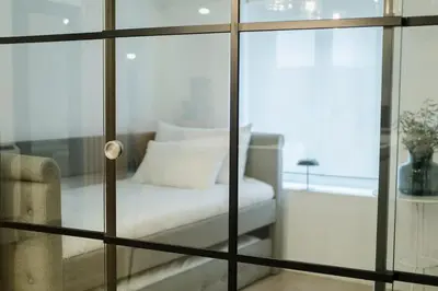 a glass room with a bed and a window at Ático Isabel, diseño y calidez junto a la Muralla Romana in Lugo