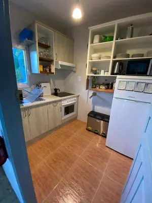 a kitchen with a white refrigerator and a wooden floor at Casa de las Ascuas in Ourense