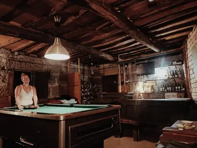 a woman standing in a room with a pool table at Casa de las Ascuas in Ourense