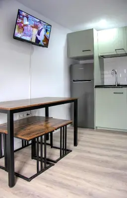 a kitchen with a table and a tv on the wall at Apartamento El descanso de Fuco in Molinaseca