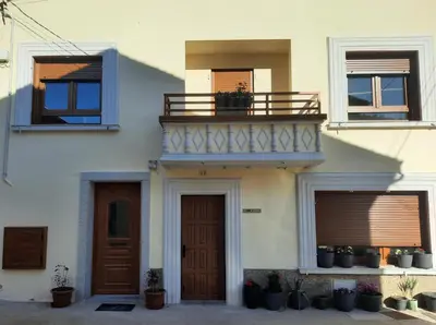 a white house with a balcony and a door at Apartamento El descanso de Fuco in Molinaseca