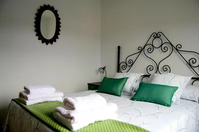 a bedroom with a bed with green and white towels at Apartamento El descanso de Fuco in Molinaseca