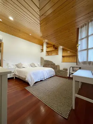 a bedroom with a bed in a room with wooden ceilings at La Casita in Nogueira de Ramuin