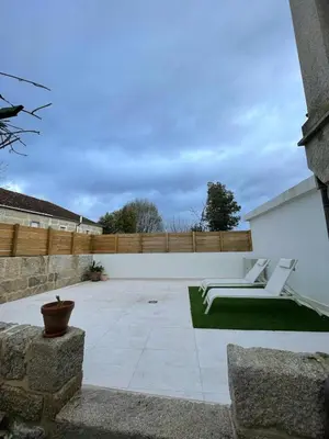 a patio with two white chairs and a fence at La Casita in Nogueira de Ramuin