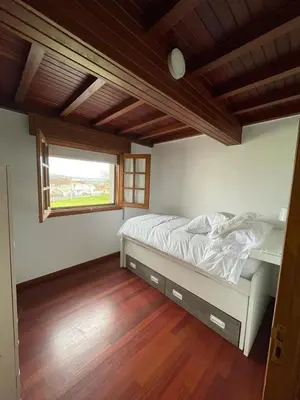 a bedroom with a bed in a room with a window at La Casita in Nogueira de Ramuin