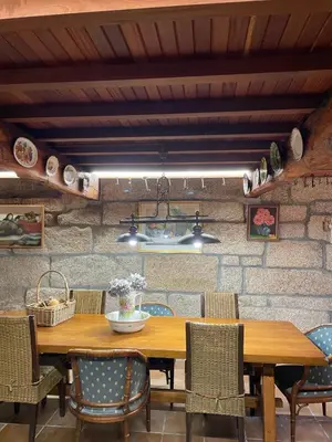 a dining room with a wooden table and chairs at La Casita in Nogueira de Ramuin