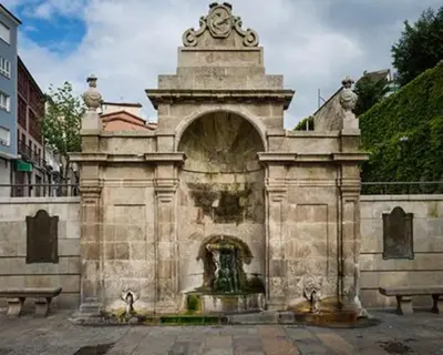 a stone building with a fountain in a courtyard at La Casita in Nogueira de Ramuin