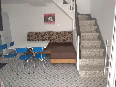 a staircase with a table and chairs and a couch at A Travesía Dos Soños, Pedreiras in Sarria
