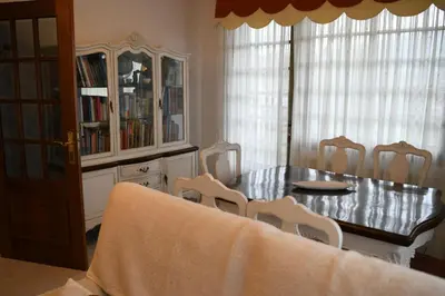 a dining room with a table and chairs and a book shelf at O Monteiriño in Arbo