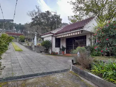 a small white house with a brick driveway at O Monteiriño in Arbo