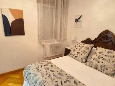 a bedroom with a bed with a wooden headboard at Los Hidalgos de Lemos in Monforte de Lemos