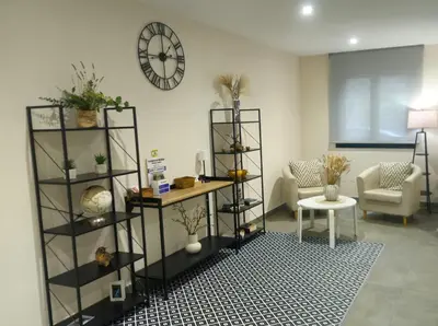 a living room with a clock on the wall at Apartamentos O Caneiro in Portomarin