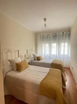 a bedroom with two beds and a window at Apartamento con encanto en Cuntis in Cuntis