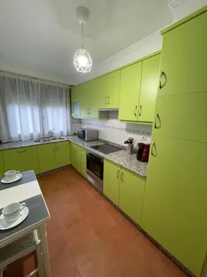 a kitchen with lime green cabinets and a table at Apartamento con encanto en Cuntis in Cuntis