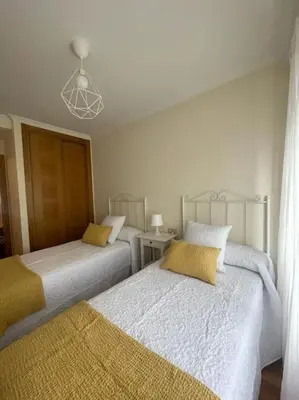 a bedroom with two beds and a chandelier at Apartamento con encanto en Cuntis in Cuntis