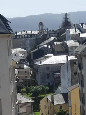 a city with buildings and a lighthouse in the distance at Apartamento Exclusivo Céntrico con parking Estrella de Ribadeo II in Ribadeo