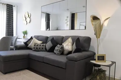 a gray couch with pillows in a living room at Apartamento Exclusivo Céntrico con parking Estrella de Ribadeo II in Ribadeo