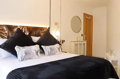 a bedroom with a large bed with black pillows at Apartamento Exclusivo Céntrico con parking Estrella de Ribadeo II in Ribadeo