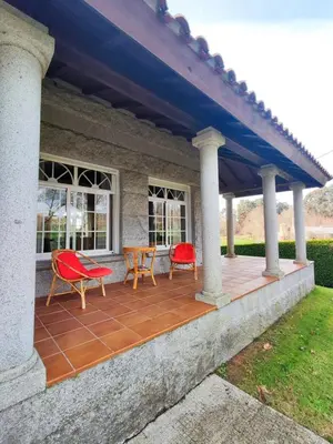 a porch with two chairs and a table at Casa Sanmartín in Maside