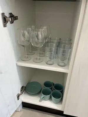 a cupboard with wine glasses and plates and bowls at Apartamento céntrico con vistas in Santiago de Compostela