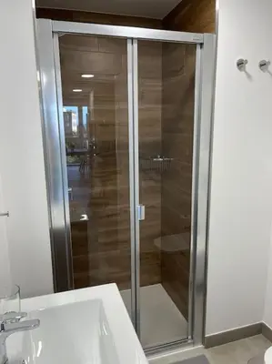 a glass shower in a bathroom with a sink at Apartamento céntrico con vistas in Santiago de Compostela