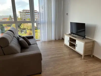 a living room with a couch and a flat screen tv at Apartamento céntrico con vistas in Santiago de Compostela