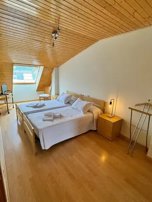 a bedroom with a large bed with a wooden ceiling at Orbayu apartamento Foz in Foz