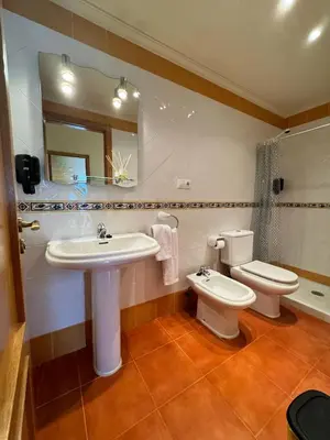 a bathroom with a sink and a toilet and a mirror at Orbayu apartamento Foz in Foz