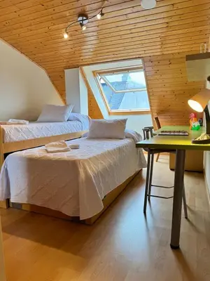 two beds in a room with a window and a table at Orbayu apartamento Foz in Foz