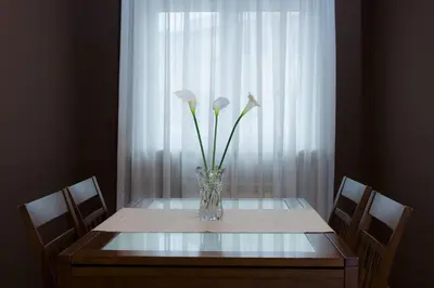 a table with a vase with flowers on it at Alojamiento Santa Maria in Milladoiro