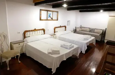 a room with two beds and a couch at A casa do pozo - AS CASAS DO POZO - in Folgoso