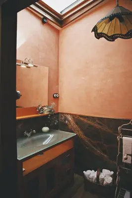 a bedroom with a bed with two lamps and a stone wall at La Casita de Coelho in Doade
