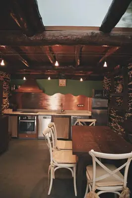 a kitchen with a wooden table and two chairs at La Casita de Coelho in Doade