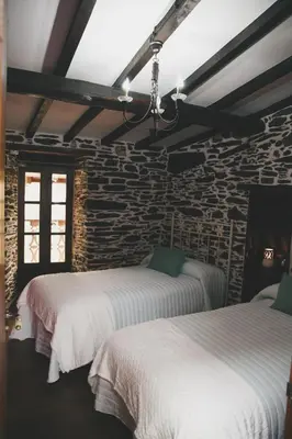 a living room with tables and benches in a building at La Casita de Coelho in Doade