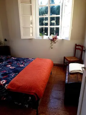 a bedroom with a bed and a window and a chair at Casa Natura Galicia in Santa María La Mayor del Rosario