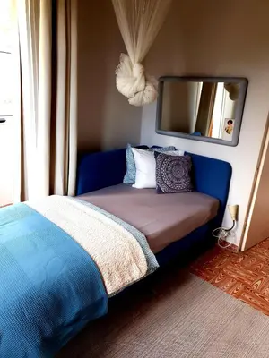 a bedroom with a blue bed and a mirror at Casa Natura Galicia in Santa María La Mayor del Rosario