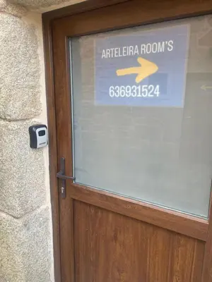 a sign on the door of a building with an arrow at Arteleira2 Rooms in Padrón