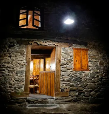 a stone house with a light on top of it at A casa dos carros - AS CASAS DO POZO - in Folgoso