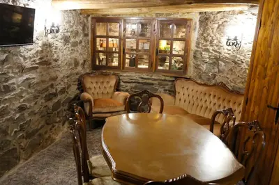 a dining room with a wooden table and chairs at A casa dos carros - AS CASAS DO POZO - in Folgoso