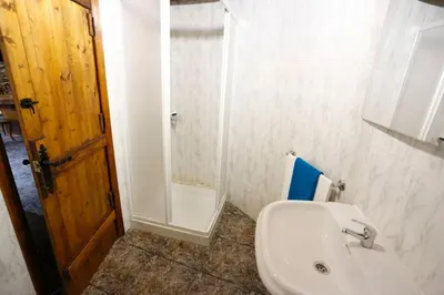 a bathroom with a white sink and a shower at A casa dos carros - AS CASAS DO POZO - in Folgoso
