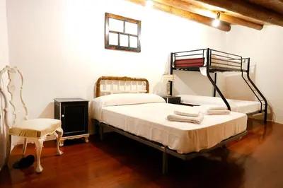 a bedroom with two beds and a chair at A casa dos carros - AS CASAS DO POZO - in Folgoso