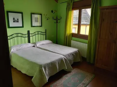 a green bedroom with two beds and a window at Casa Rural La Fuente in Tejedo del Sil