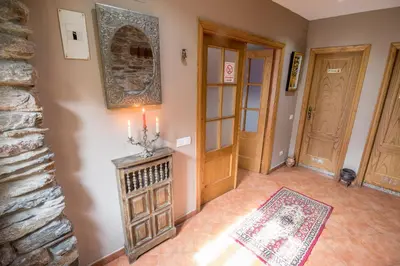 a hallway with two doors and a rug and candles at Casa Rural La Fuente in Tejedo del Sil